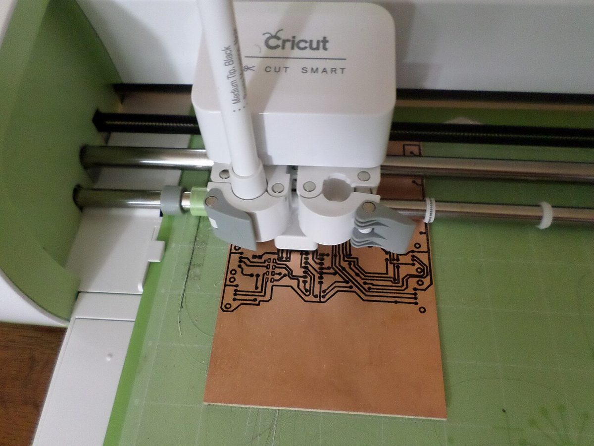 Cricut en train de découper un motif détaillé sur son tapis de découpe