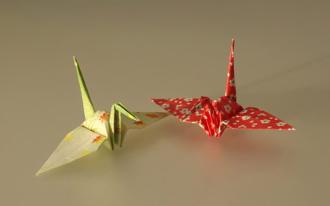 Grue en papier (orizuru) pliée en origami, posée sur un fond clair