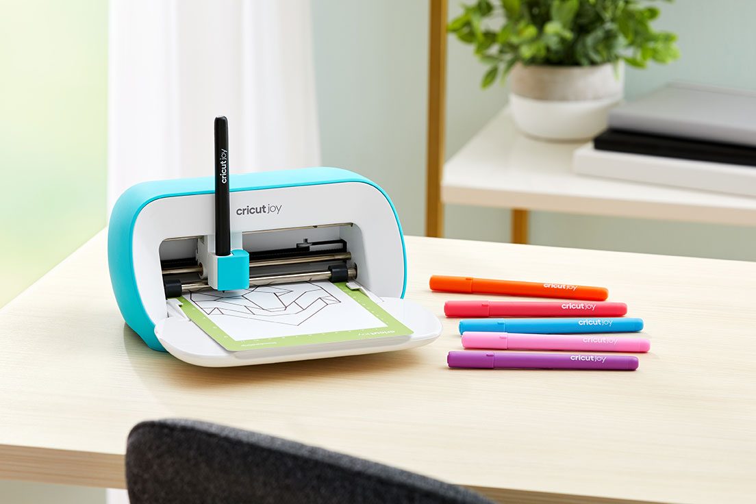 Machine de découpe Cricut Joy avec feutres colorés sur un bureau