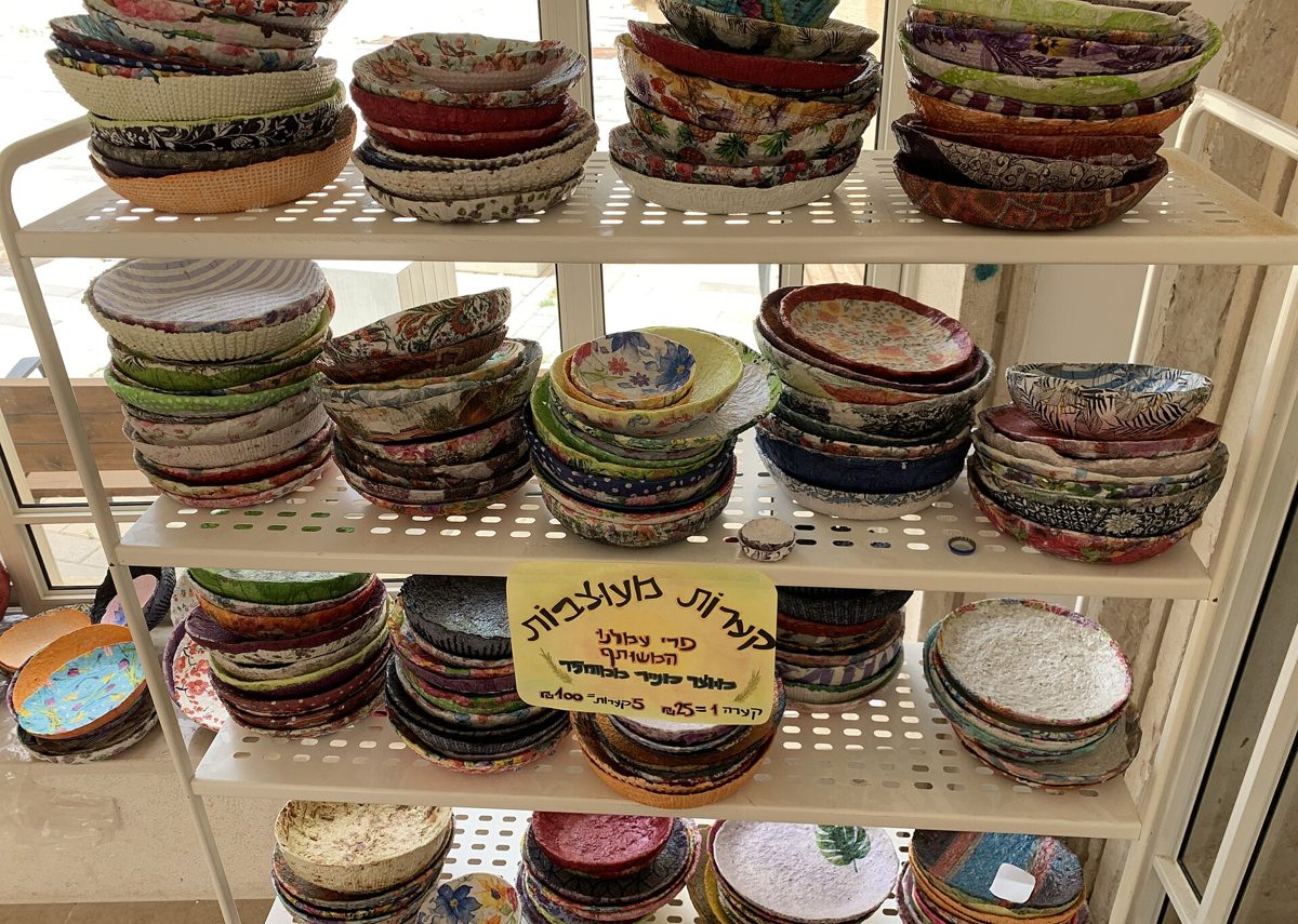 Plusieurs bols en papier mâché colorés et à motifs, posés sur des étagères