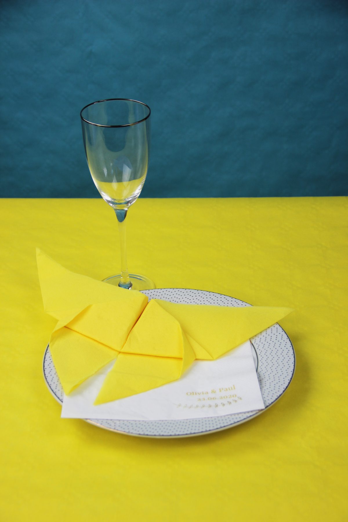 Serviette en papier pliée en forme de papillon posée sur une assiette