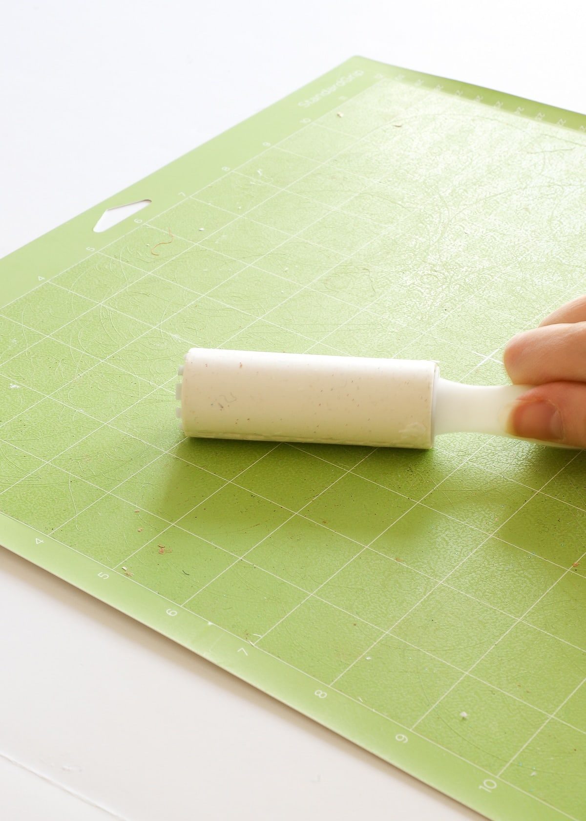 Passer un rouleau anti-peluches sur un tapis de découpe Cricut pour retirer poussières et fibres