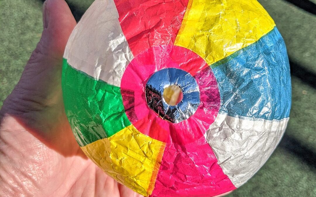 Ballon en papier (bombe à eau) coloré et gonflé, tenu dans la main, avec le petit trou pour souffler