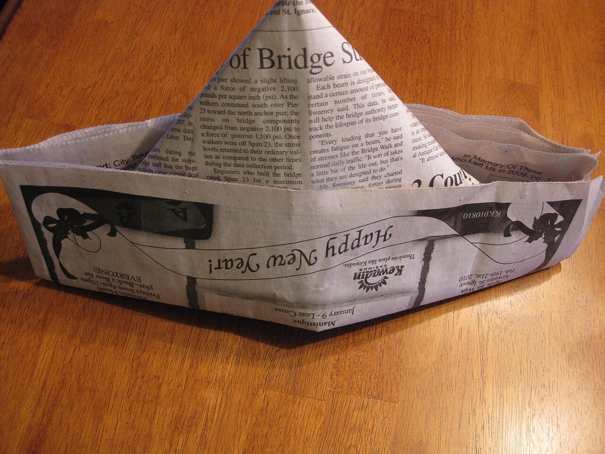 Chapeau en papier journal plié, le modèle classique porté par un enfant