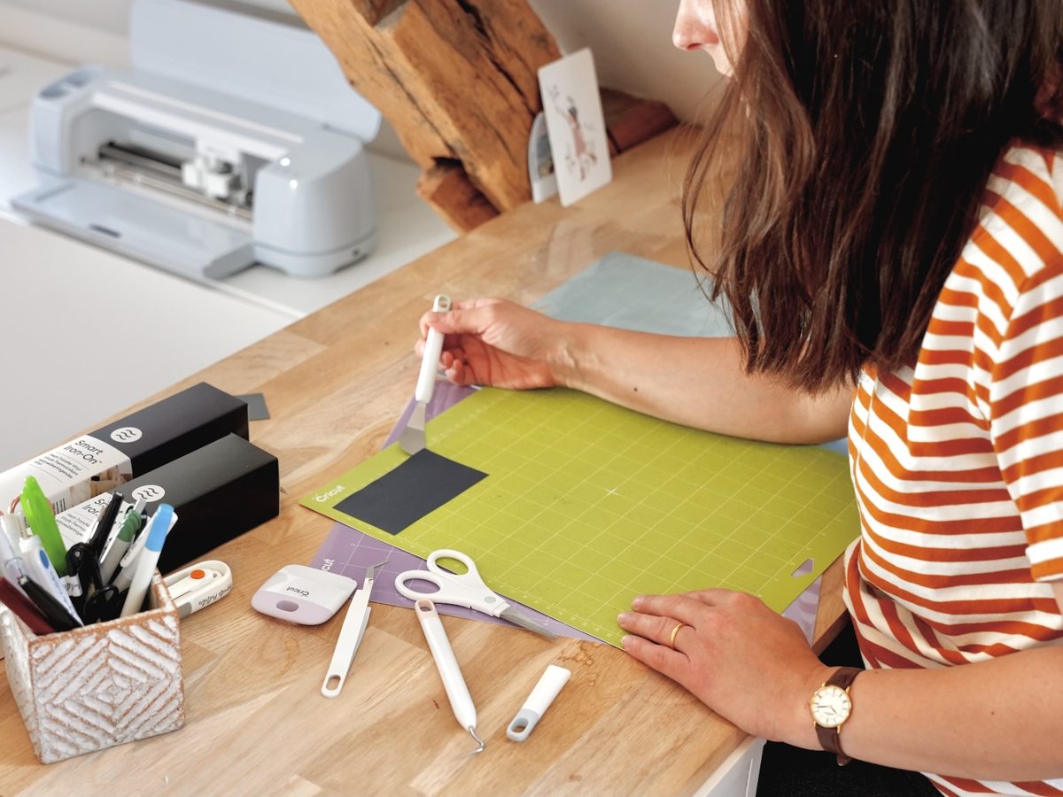 Tapis de decoupe Cricut avec papier et outils pres de la machine