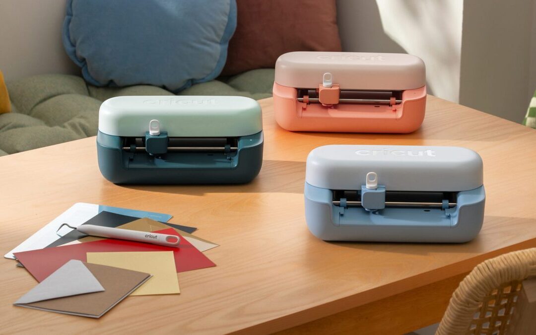 Machine de découpe Cricut posée dans un atelier créatif avec des projets papier