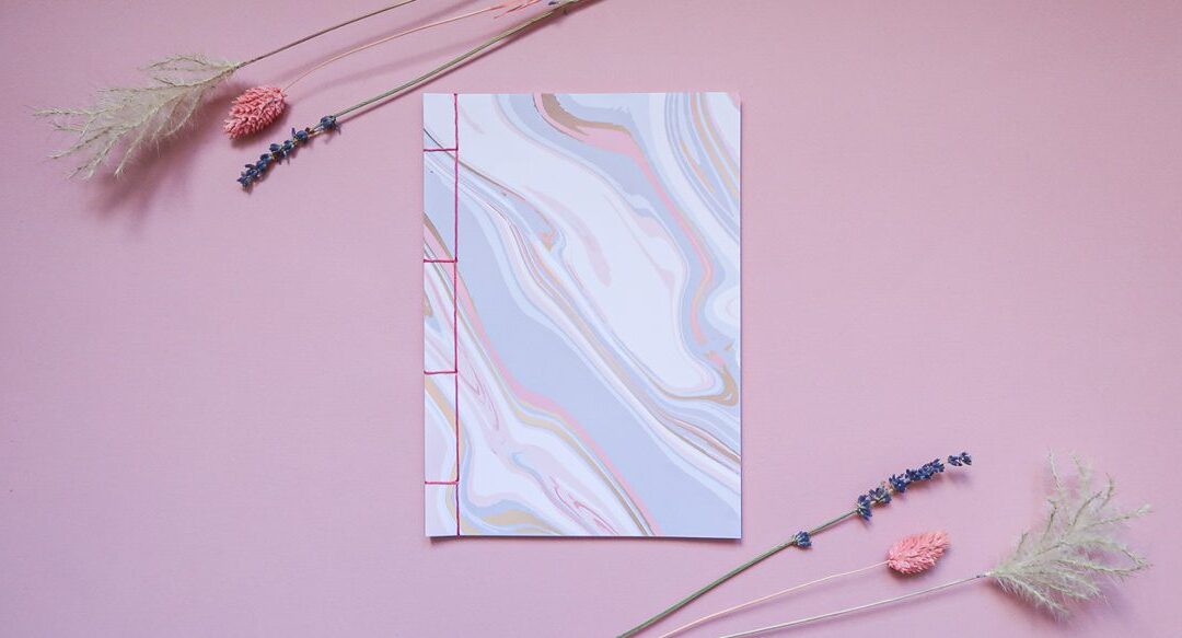 Carnet fait main relié en reliure japonaise, couverture marbrée et couture au fil rose
