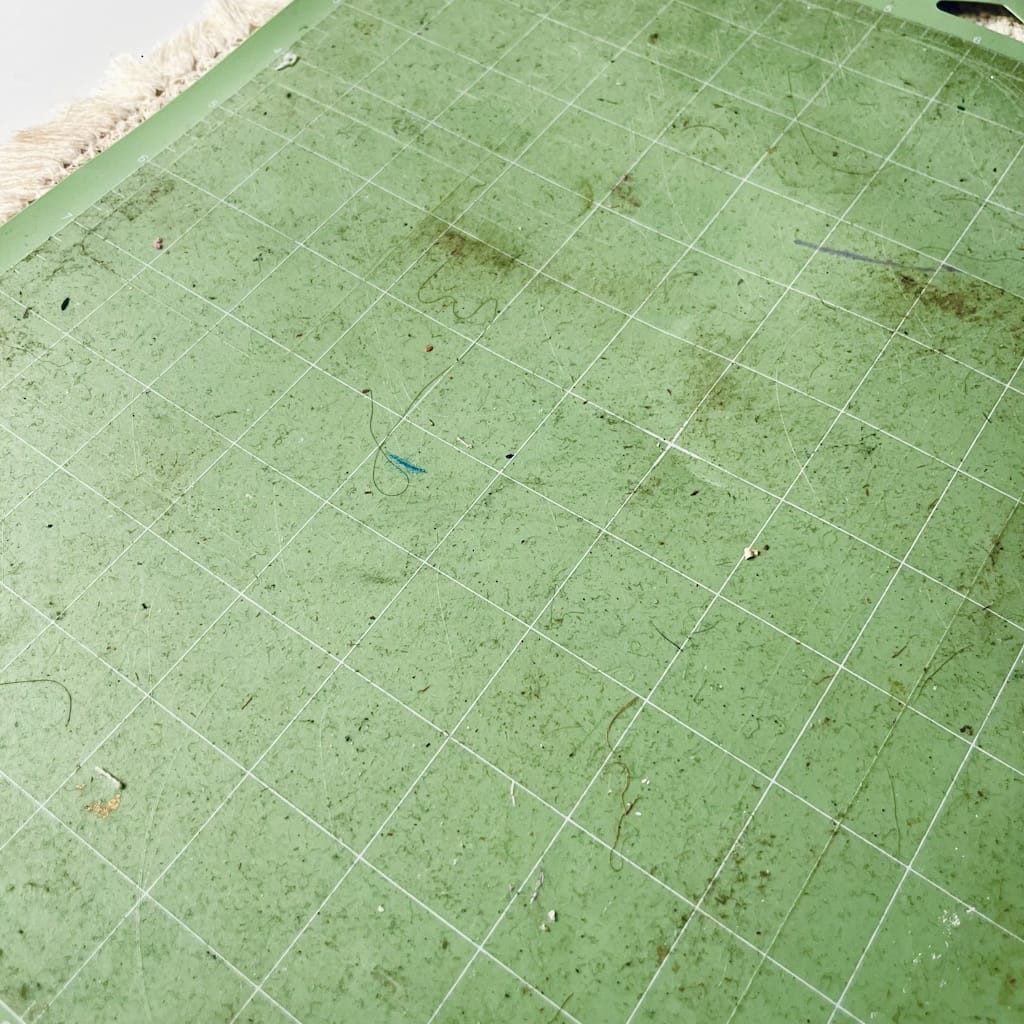Tapis de découpe Cricut vert encrassé, couvert de poussière, de cheveux et de fibres de papier