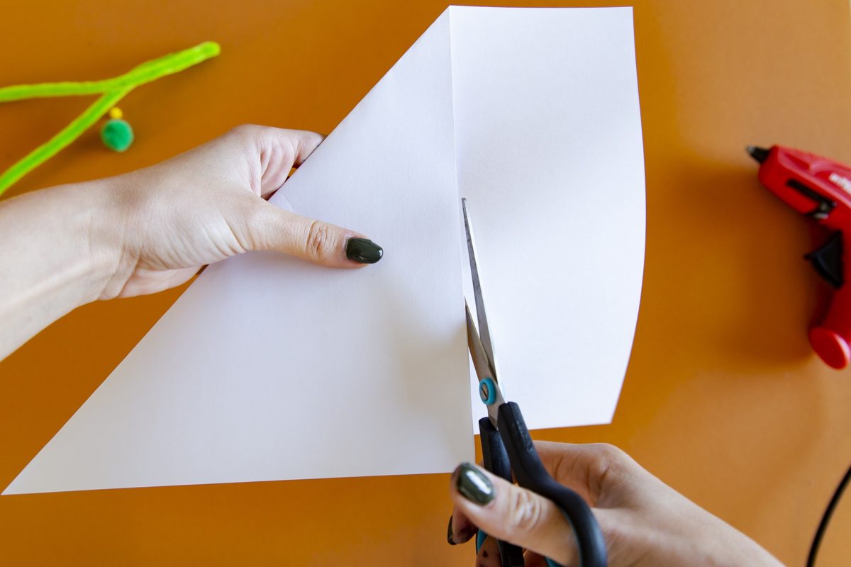 Découpe aux ciseaux d'un papier plié pour former une toile d'araignée