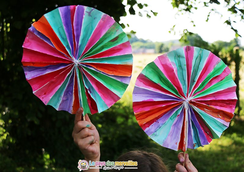 Enfant tenant des éventails en papier colorés faits maison
