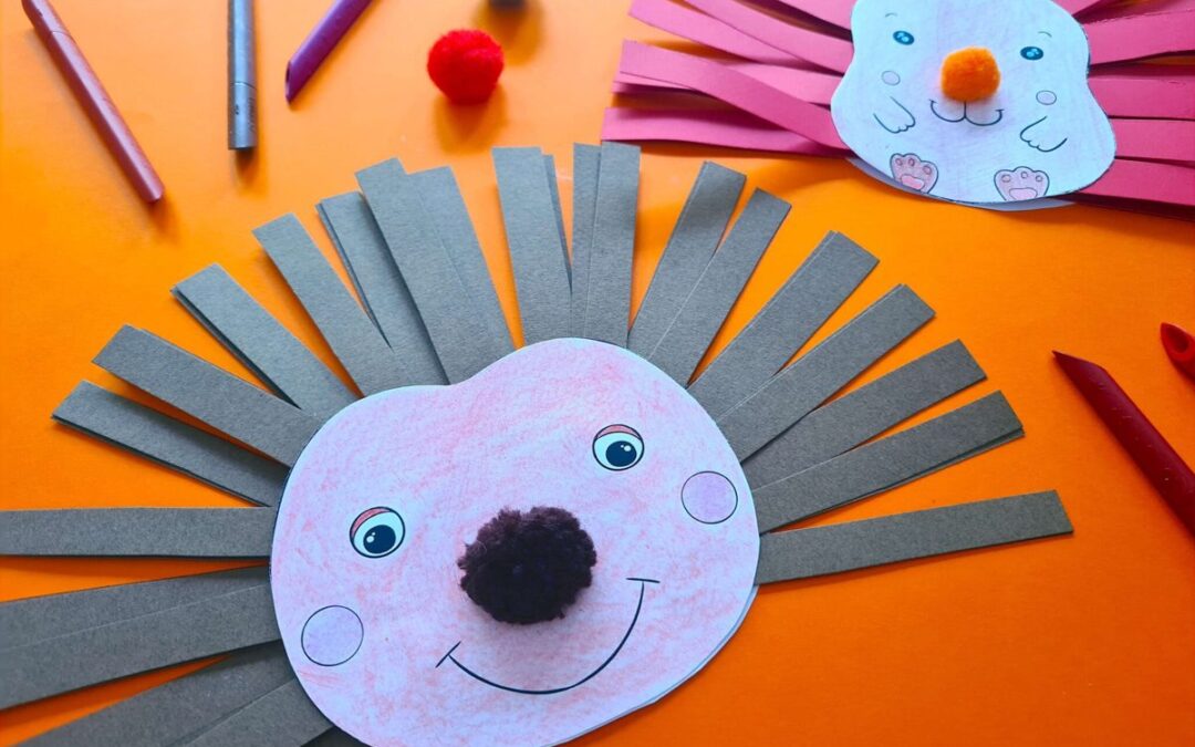 Deux hérissons en papier aux piquants faits de bandes de papier gris et rose, avec un museau en pompon, sur fond orange