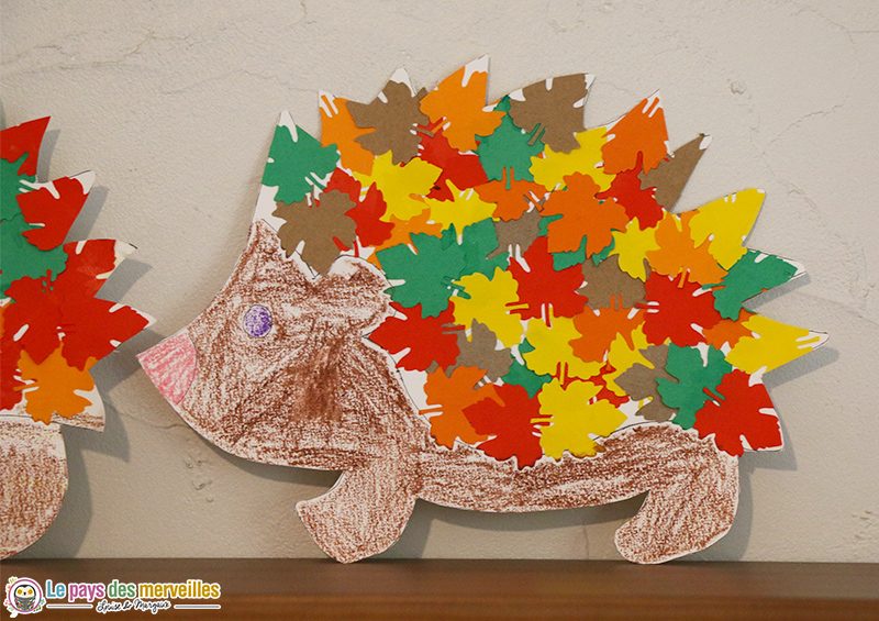 Hérisson en papier dont les piquants sont de petites feuilles de papier aux couleurs d'automne (rouge, orange, jaune, vert)