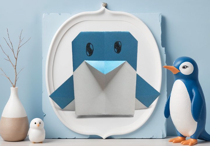 Pingouin en origami tout simple, plié à plat en papier bleu avec des yeux dessinés