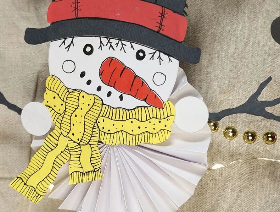 Bonhomme de neige en papier à suspendre : chapeau haut-de-forme, écharpe jaune et corps en rosace plissée