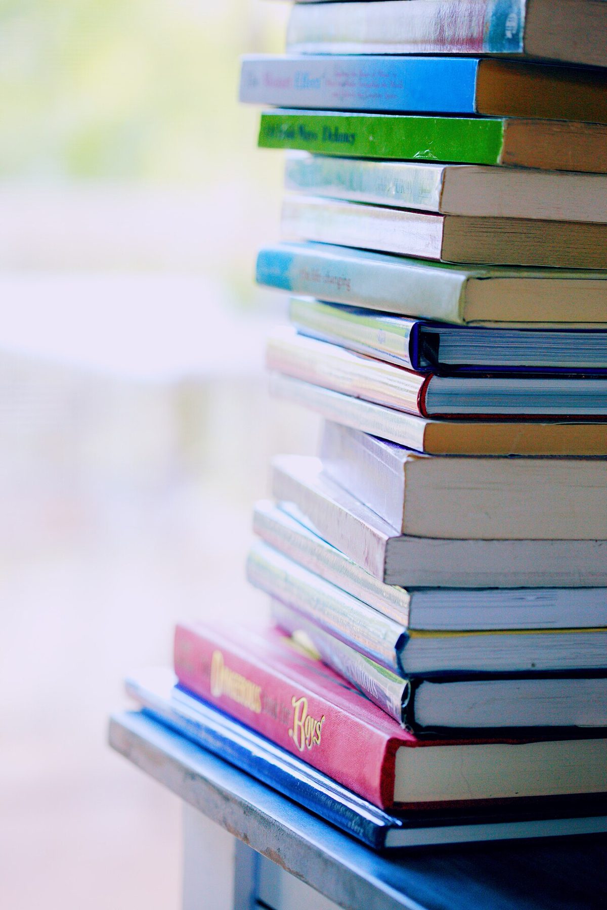 Pile de livres colorés posés sur une table, comme une pile à lire