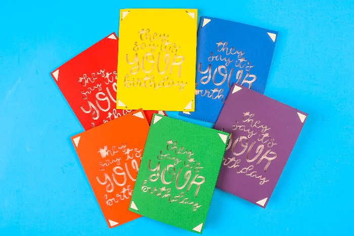 Six cartes à insérer colorées, l'insert métallique visible dans le lettrage