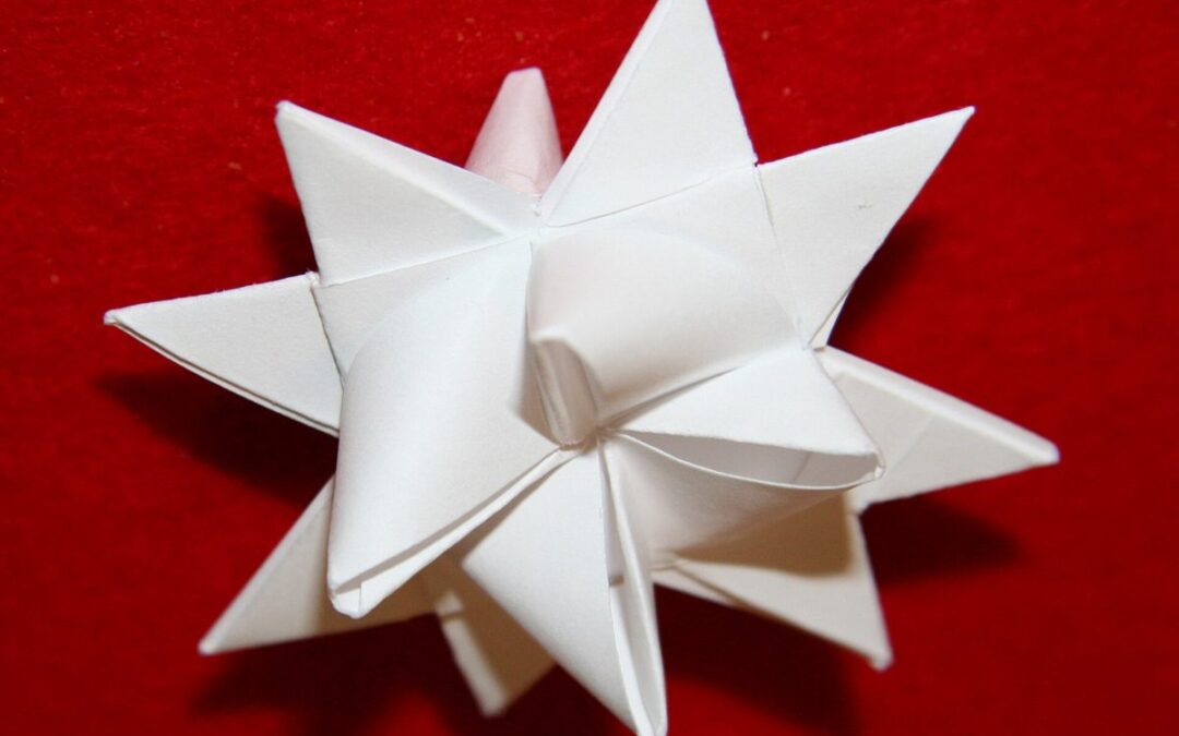 Étoile de Fröbel blanche à 16 pointes posée sur un fond de velours rouge, décoration de Noël en papier
