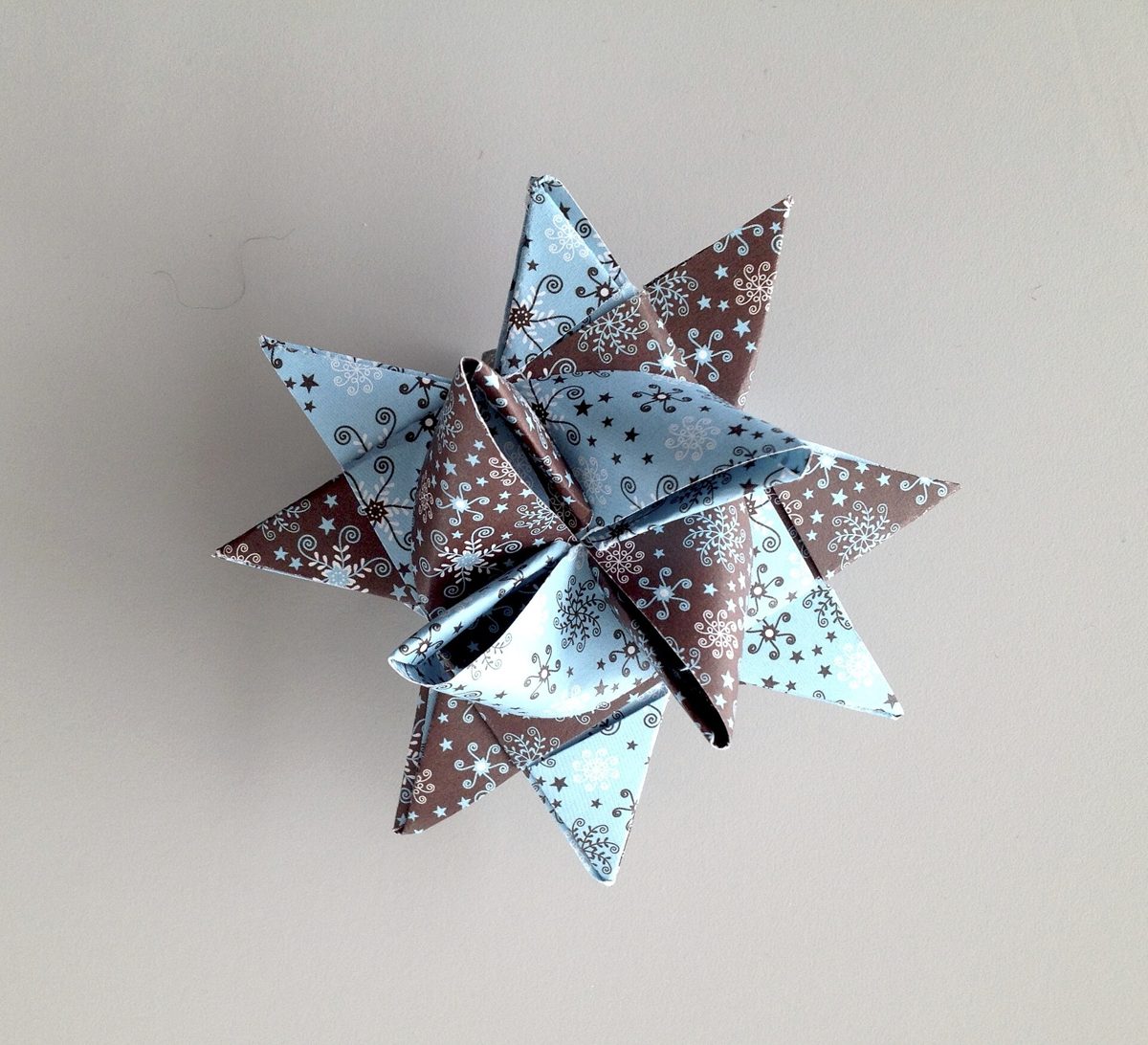 Étoile de Fröbel en papier à motifs bleu et brun montrant les pointes plates et les pointes en relief