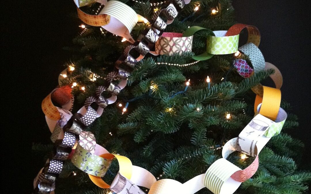 Sapin de Noël décoré de guirlandes de maillons en papier coloré, illuminé