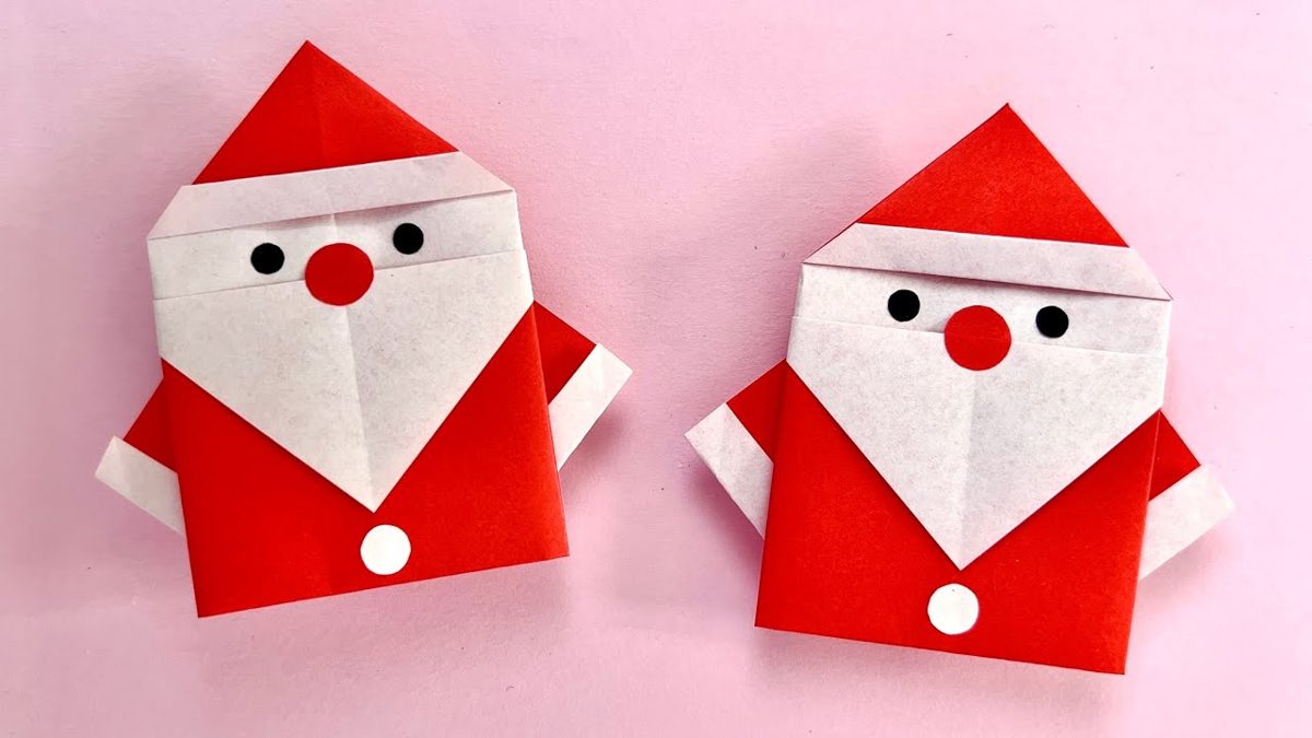 Père Noël en origami rouge terminé, posé sur une table