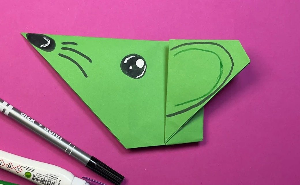 Souris en origami facile pliée dans une feuille verte, museau pointu et grande oreille dessinés au feutre
